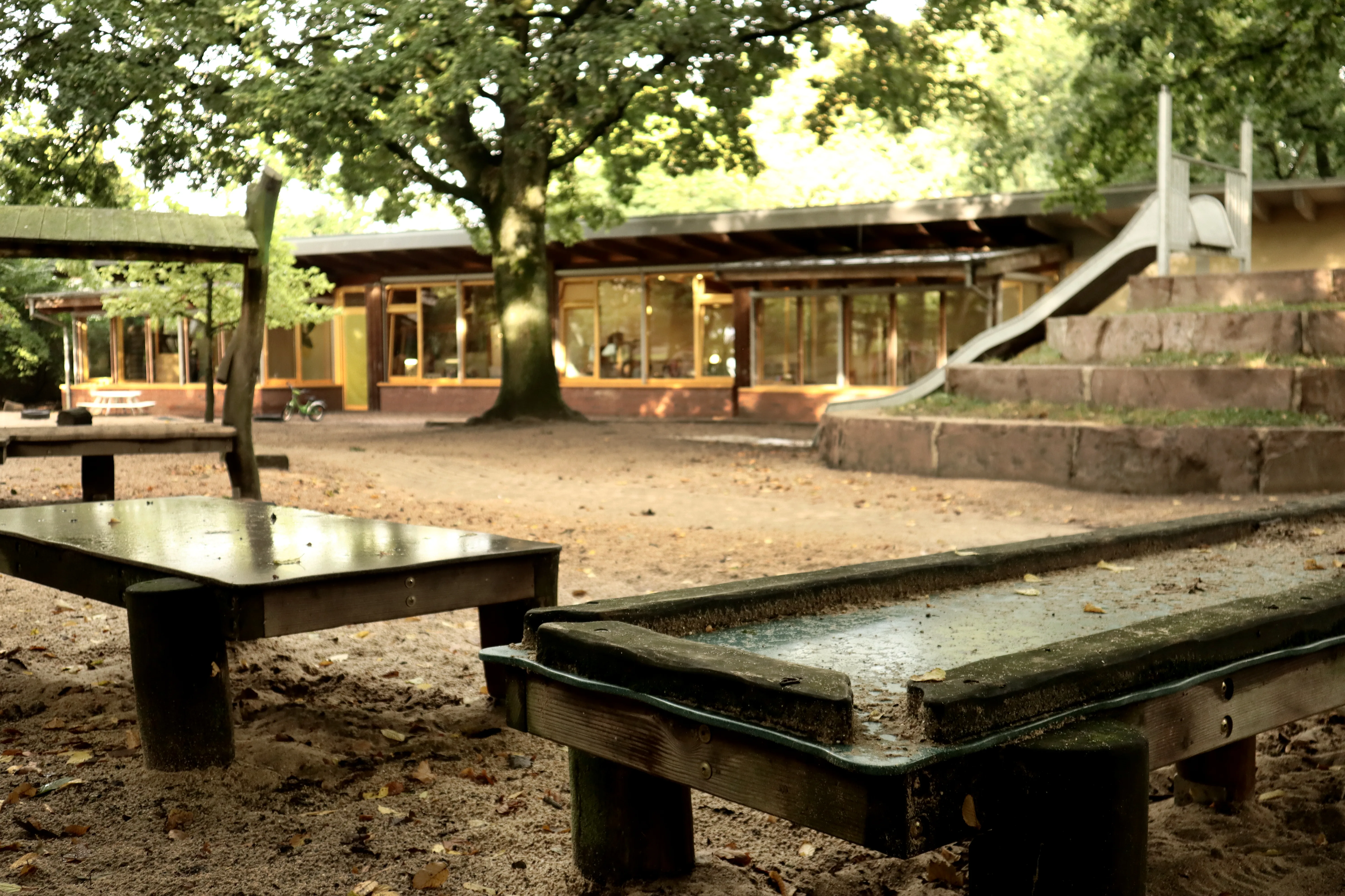 Holz-Spielgerüst mit Plattform im grünen Außengelände.